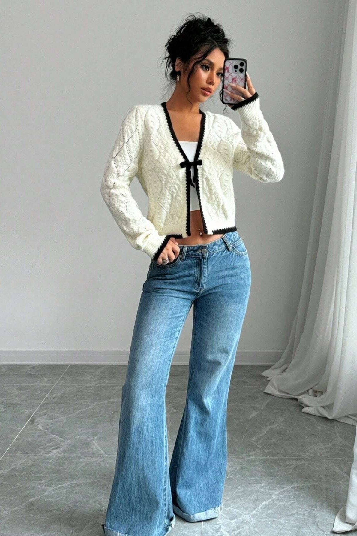 Kurze Strickjacke mit Lochmuster, Schleife und kontrastfarbenen Bordüren – Mila