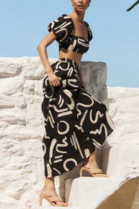 Ensemble assorti composé d'un top imprimé à épaules découvertes et d'une jupe longue avec découpes et poches, parfait pour un look d'été cool et à la mode.